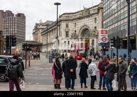 Grande autobus rosso fuori dall'ingresso alla stazione ferroviaria di Waterloo Foto Stock