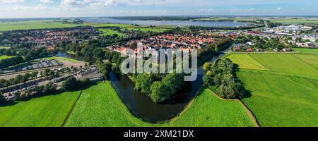 Splendida fotografia aerea che cattura un pittoresco villaggio olandese circondato da canali panoramici e vegetazione lussureggiante. Foto Stock