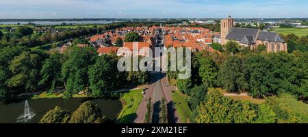 Una splendida foto aerea di un pittoresco villaggio europeo con strutture storiche, vegetazione lussureggiante e viste panoramiche. Foto Stock