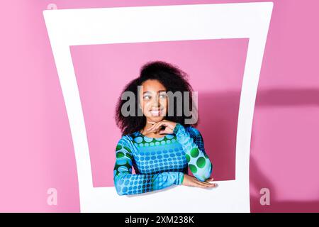 Foto di una bella giovane donna cornice fotografica istantanea look carino spazio vuoto vestito elegante indumento blu isolato su sfondo di colore rosa Foto Stock