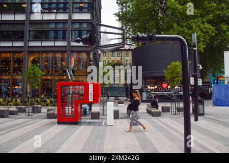 Londra, Inghilterra, Regno Unito. 25 luglio 2024. Una donna passa davanti a un lampione stradale e a una scatola telefonica. Un autobus ripiegato a grandezza naturale, una scatola telefonica, un lampione stradale e una panca sono apparsi a Spitalfields Market e Old Street, ribattezzata Fold Street, per il lancio del telefono Samsung Galaxy Z Fold6. (Credit Image: © Vuk Valcic/ZUMA Press Wire) SOLO PER USO EDITORIALE! Non per USO commerciale! Foto Stock