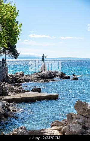 Fanciulla con una statua di gabbiano nella baia sul lungomare di Opatija Foto Stock