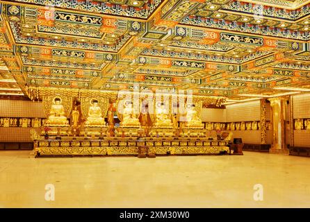 Statue del Buddha d'oro all'interno del tempio di po Lin Monas Foto Stock