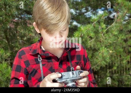 Gli adolescenti studiano e scattano foto nel parco pubblico. All'aperto. Primo piano. Estate. Foto Stock