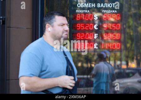 Uomo vicino all'ufficio di cambio valuta sulla strada della città, tassi del rublo russo, dollaro americano, euro Foto Stock