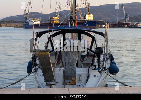 yacht attraccato nel porto commerciale al tramonto Foto Stock