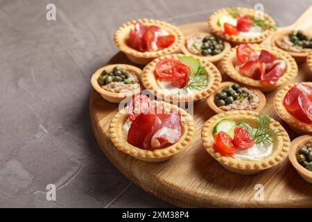 Deliziosi stuzzichini con jamon, pate e salsicce affumicate asciutte su un tavolo testurizzato grigio Foto Stock