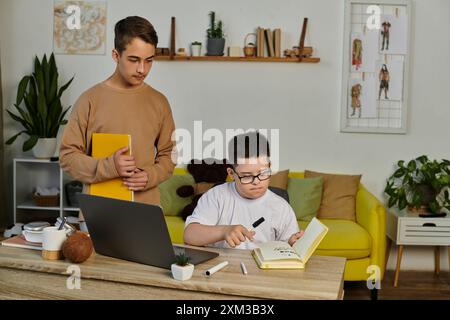 Un ragazzo con la sindrome di Down studia a casa con i suoi amici. Foto Stock