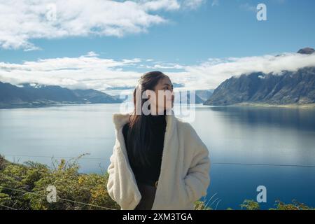 Bella donna asiatica felice che si gode con vista panoramica sul lago Hawea in autunno in nuova Zelanda Foto Stock