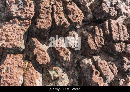 consistenza di rocce rosse erose dal passare del tempo situate nel deserto in una giornata di sole illuminata dalla luce naturale Foto Stock