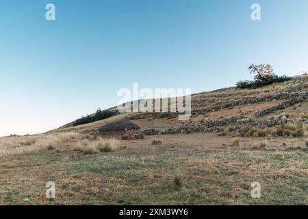 capanna e capanna su una montagna nelle Ande del Perù in un tramonto con un cielo blu circondato da vegetazione verde e alberi Foto Stock