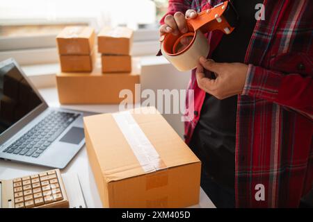 le confezioni dei pacchi sono confezionate e pronte per essere inviate ai clienti che hanno effettuato ordini online nel sistema del negozio online. Un piccolo imprenditore di piccole e medie dimensioni Foto Stock