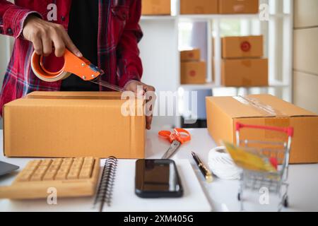 le confezioni dei pacchi sono confezionate e pronte per essere inviate ai clienti che hanno effettuato ordini online nel sistema del negozio online. Un piccolo imprenditore di piccole e medie dimensioni Foto Stock