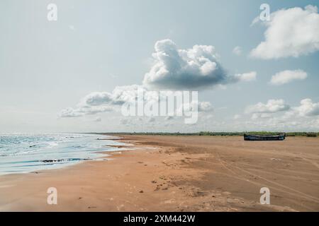 Il Mar Caspio sotto la minaccia della desertificazione, vecchio peschereccio in legno abbandonato sulla riva, un po' di verde in lontananza Foto Stock