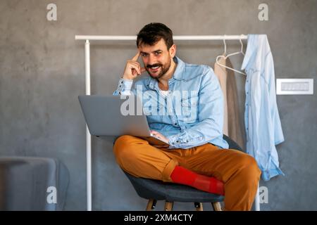 Tecnologia concetto di lavoro e stile di vita in remoto. Uomo di successo con il computer portatile che lavora in ufficio a casa Foto Stock