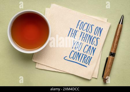 Concentratevi sulle cose che potete controllare: Consigli ispiratori o promemoria su un tovagliolo con tazza di tè, concetto di gestione del tempo Foto Stock