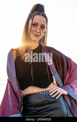 Donna alla moda in un outfit futuristico al tramonto. Foto Stock