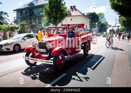 MARIEHAMN, Åland, FINLANDIA - LUGLIO 25 2024: Un antico motore antincendio segue la tradizionale parata dell'equipaggio delle navi del 57 per le strade di Mariehamn. Secondo giorno della terza tappa Åland della corsa delle navi alte 2024 nel porto principale, Mariehamn, Åland, Finlandia. Foto: Rob Watkins/Alamy Live News. INFO: La Tall Ships Race è un evento velico annuale che comprende navi d'alto livello storiche e moderne. Promuove l'amicizia internazionale e la formazione dei giovani, attirando partecipanti e spettatori in tutto il mondo per celebrare il patrimonio marittimo e l'arte della vela tradizionale. Foto Stock