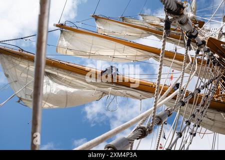 MARIEHAMN, Åland, FINLANDIA - LUGLIO 25 2024: I marinai salgono in alto nel cielo per lavorare sulle vele sugli alberi del sommergibile Guayas dall'Ecuador. Secondo giorno della terza tappa Åland della corsa delle navi alte 2024 nel porto principale, Mariehamn, Åland, Finlandia. Foto: Rob Watkins/Alamy Live News. INFO: La Tall Ships Race è un evento velico annuale che comprende navi d'alto livello storiche e moderne. Promuove l'amicizia internazionale e la formazione dei giovani, attirando partecipanti e spettatori in tutto il mondo per celebrare il patrimonio marittimo e l'arte della vela tradizionale. Foto Stock