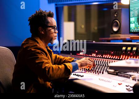 Console audio per produttore musicale in sala di controllo con apparecchiature di editing e mixaggio professionali, concetto di post-produzione. Sound designer elaborazione tracce, software digitale. Foto Stock