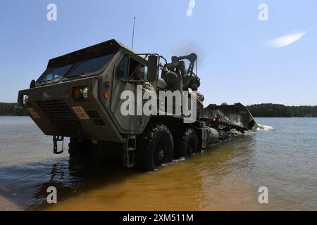 Michael Igwe, un membro dell'equipaggio del ponte della 125th Multi-Role Bridge Company, South Carolina Army National Guard, lancia una sezione migliorata del Ribbon Bridge sul fiume Savannah durante una missione di addestramento presso il Clarks Hill Training Site, S.C., 17 luglio 2024. Durante la missione di addestramento i membri dell'unità utilizzarono sezioni di ponte per costruire una zattera per trasportare truppe, veicoli e attrezzature attraverso il fiume. I soldati con l'esercito colombiano hanno osservato l'addestramento come parte di uno scambio attraverso il programma di partenariato della Guardia Nazionale del Dipartimento della difesa, che associa gli elementi della Guardia con le nazioni partner Foto Stock