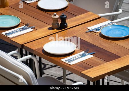 Prima dell'ora di pranzo, un elegante e vuoto caffè sulla spiaggia con tavoli serviti che aspettano gli ospiti nella soleggiata Biarritz, Paesi Baschi, Francia Foto Stock