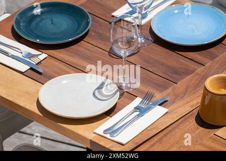 Prima dell'ora di pranzo, un elegante e vuoto caffè sulla spiaggia con tavoli serviti che aspettano gli ospiti nella soleggiata Biarritz, Paesi Baschi, Francia Foto Stock