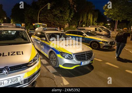 Amburgo, Germania. 25 luglio 2024. Gli agenti di polizia stanno in piedi su una strada durante un'operazione nel quartiere di Amburgo di Lurup. Un uomo apparentemente instabile mentalmente ha innescato un'importante operazione di polizia ad Amburgo-Lurup. Credito: Bodo Marks/dpa/Alamy Live News Foto Stock