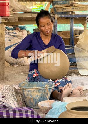 Donna che lancia argilla mentre costruisce un vaso usando mezzi tradizionali, la Cambogia. Foto Stock