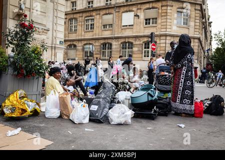 I senzatetto attendono una soluzione abitativa di fronte al 18° arrondissement Municipio. Dozzine di famiglie migranti senzatetto hanno trascorso tre giorni e due notti in Place Jules Joffrin, di fronte al 18° arrondissement Municipio, a Parigi, per chiedere il loro diritto all'alloggio. Un'unità di polizia stava formando un perimetro, che non consentiva a nessuno di uscire o entrare, il che causava la separazione delle famiglie. Fu solo il terzo giorno che la prefettura trovò un alloggio nella zona dell'Ile de France, ma non sapeva quanto sarebbe durato il rifugio. Foto Stock