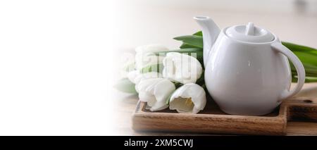 Teiera e tulipani bianchi sul tavolo. Banner per il design Foto Stock