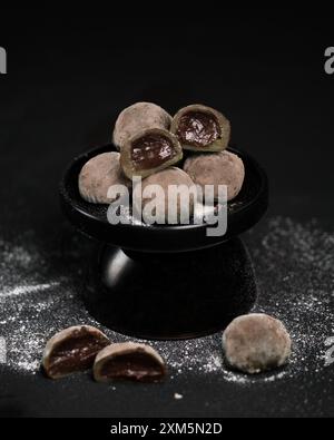 primo piano di un piatto di mochi di cioccolato su un tavolo Foto Stock