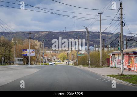 Le strade cittadine di Zhigulevsk, una città nella regione di Samara, con edifici in stile sovietico, automobili e montagne Zhiguli intorno. Foto Stock