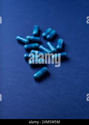Capsule di aminoacidi su sfondo di carta scura. Messa a fuoco morbida. Foto Stock