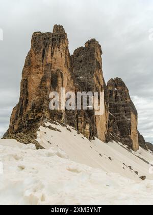 Camminate attraverso la neve di giugno sul circuito tre Cime, con cime dolomitiche che appaiono attraverso la nebbia Foto Stock