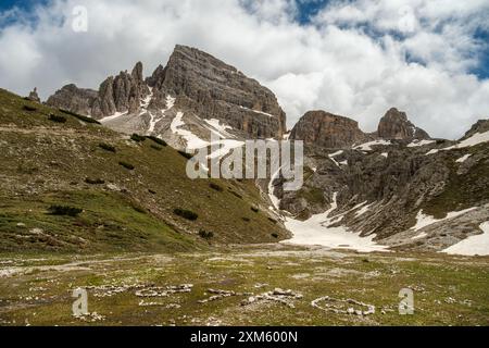 Paesaggio innevato sul circuito tre Cime con cime dolomitiche che emergono dalle nuvole e dalla nebbia di giugno Foto Stock
