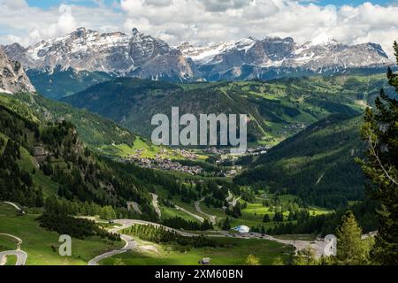 Goditi le curve panoramiche della strada serpentina che si snoda attraverso il passo Gardena e verso Colfosco, con lo splendido sfondo di montagna che incornicia il tuo Foto Stock