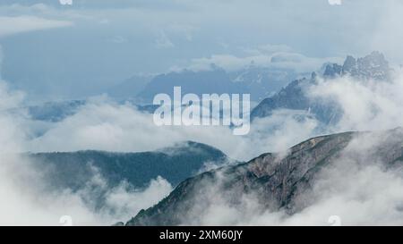 Neve e nebbia mistica sul circuito tre Cime, con le aspre cime delle Dolomiti alte. Foto Stock