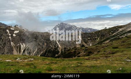Presentazione delle Dolomiti: Giugno escursione sul circuito tre Cime con sentieri innevati e cime nebbiose Foto Stock
