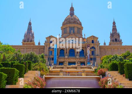 Barcellona, Spagna - 16 luglio 2024: Vista frontale prominente del Palau Nacional incorniciata da giardini colorati. Foto Stock