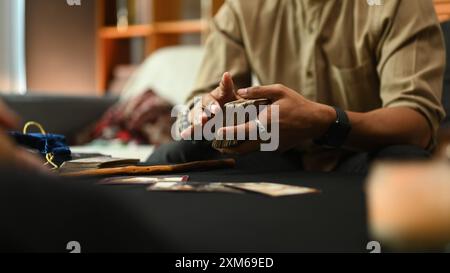 Indovino che distribuisce carte di Tarocchi disposte su un tavolo ricoperto di tessuto mistico. Concetto di divinazione Foto Stock