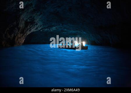 Guide in barca a remi che portano i turisti nella Grotta Azzurra di Capri Foto Stock