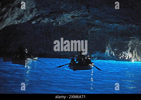 Guide in barca a remi che portano i turisti nella Grotta Azzurra di Capri Foto Stock