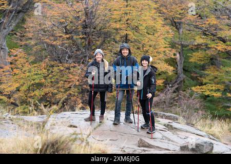 Tre persone sono in piedi su una collina rocciosa, indossando zaini Foto Stock