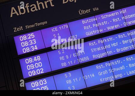 Rostock, Germania. 26 luglio 2024. Una bacheca presso la stazione principale fornisce informazioni sui treni in partenza. Lo scorso fine settimana, la prima delle vacanze estive nel Meclemburgo-Pomerania Occidentale, ci sono stati treni sovraffollati e cancellazioni dei treni sui servizi regionali, come dimostrano i post della Deutsche Bahn MV sulla piattaforma X credito: Bernd Wüstneck/dpa/Alamy Live News Foto Stock