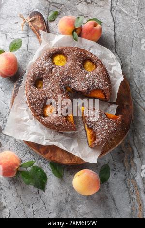 Deliziosa torta brownie al cioccolato alla pesca primo piano su una tavola di legno sul tavolo. Vista dall'alto verticale Foto Stock