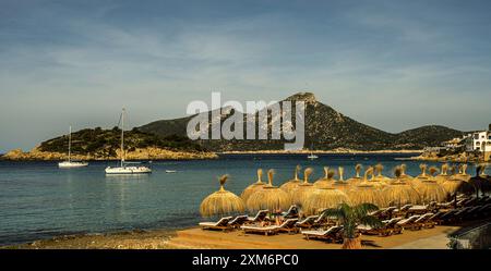 Ombrelloni sulla spiaggia di Sant Elm, vista della baia e dell'isola di sa Dragonera, Maiorca, Spagna Foto Stock