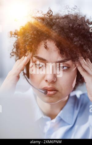 una ragazza in un ufficio moderno che lavora in un call center si concentra sulla spiegazione della procedura Foto Stock