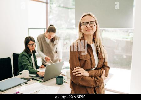 Ritratto di una donna d'affari bionda e cosmopolita moderna in ufficio. Foto Stock