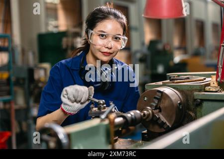 Ritrattista felice ingegnere con occhiali di protezione per gli occhi di sicurezza professionale che lavora con la fresatrice per tornio in metallo fabbrica dell'industria pesante. Foto Stock